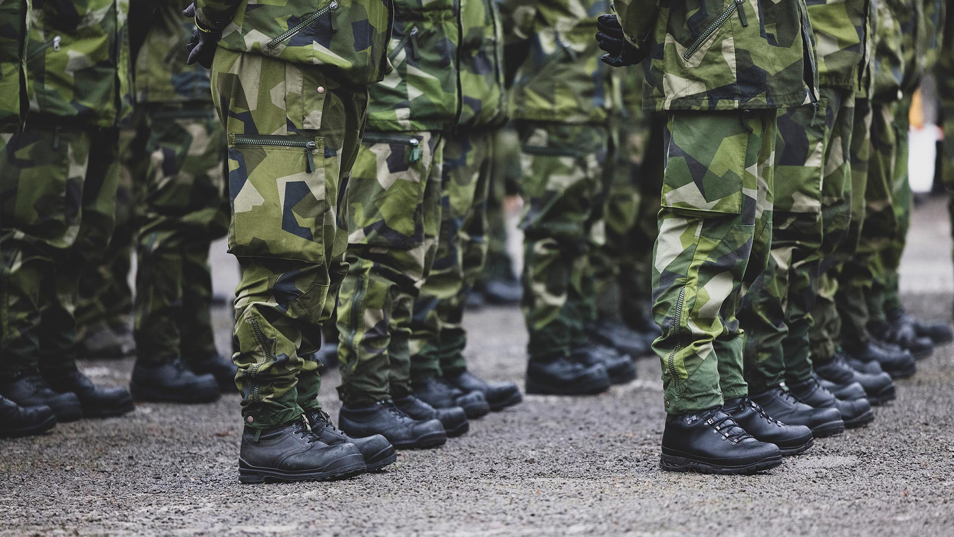 Legs of Swedish soldiers in green camouflage uniform